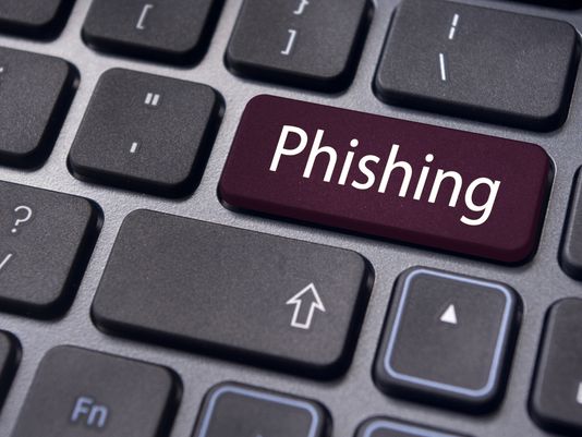 A computer keyboard with a large maroon key labeled "Phishing" replacing the usual Enter key.