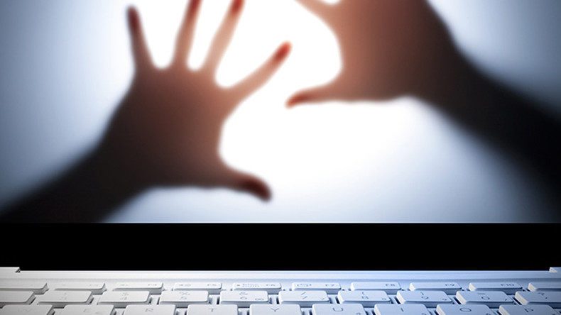 A close-up of a white computer keyboard with two shadowy hands pressed against a lit screen in the background, creating a sense of urgency or distress.