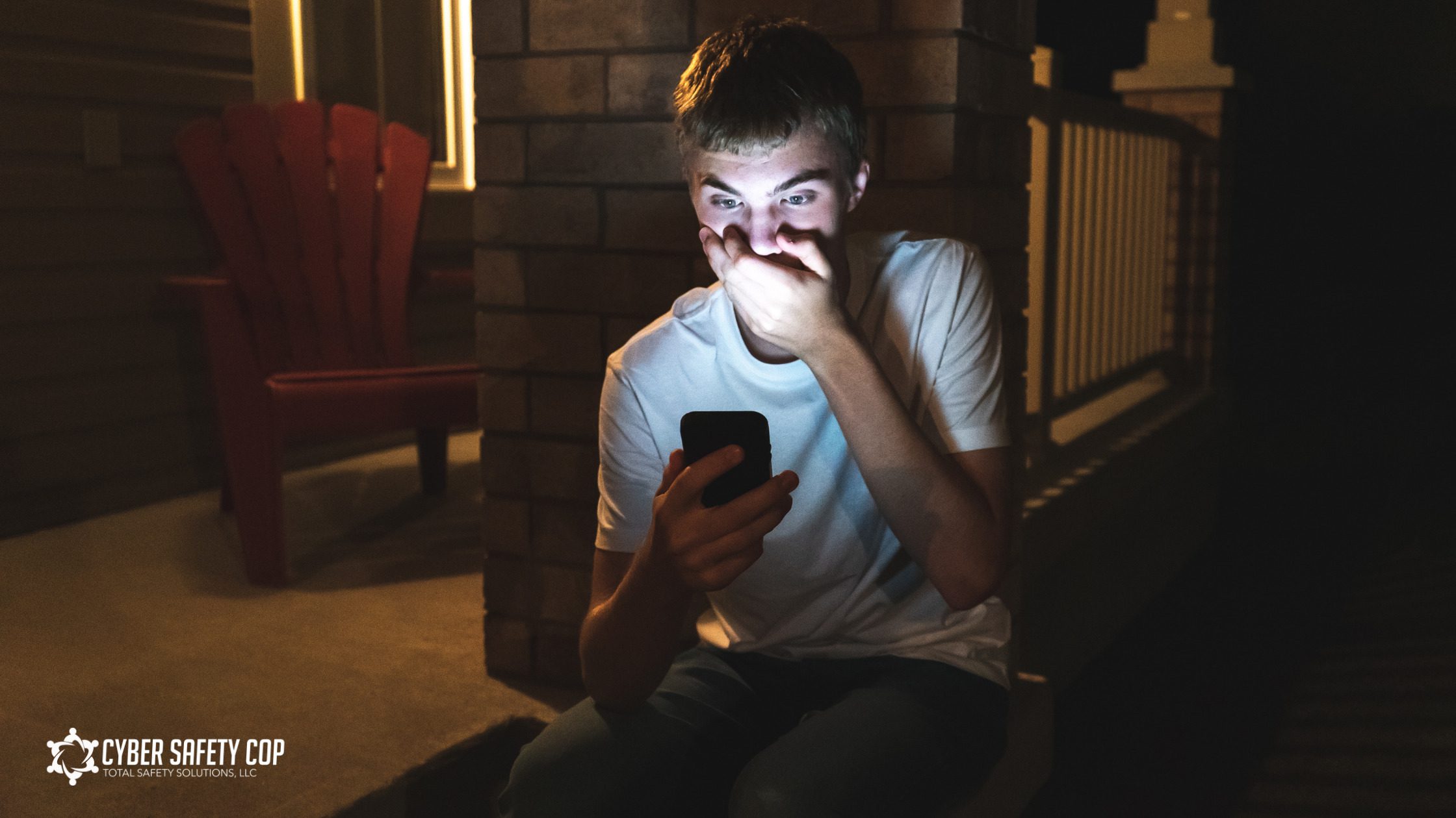 A teenage boy sits outside at night, illuminated by his phone screen, covering his mouth in shock or worry. The logo "Cyber Safety Cop" appears in the bottom left corner of the image.
