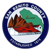 Seal of San Benito County featuring a white building with a red roof, mountains, and a green map marking Hollister. Text reads "San Benito County Established 1874.
