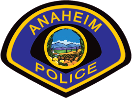 Anaheim Police badge logo with yellow text on blue background, featuring a circular illustration of fields, trees, and mountains under a blue sky.
