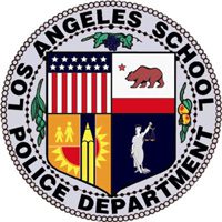 Seal of the Los Angeles School Police Department featuring a shield with symbols: the US flag, California bear, children by the sun and buildings, and a woman holding scales, surrounded by the department name in a circular border.