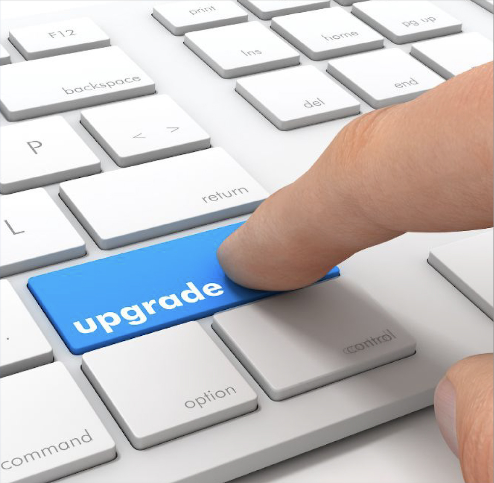 A close-up of a hand pressing a bright blue "upgrade" key on a white computer keyboard, with surrounding keys labeled "shift," "return," and "option," symbolizing an upgrade on the membership page.