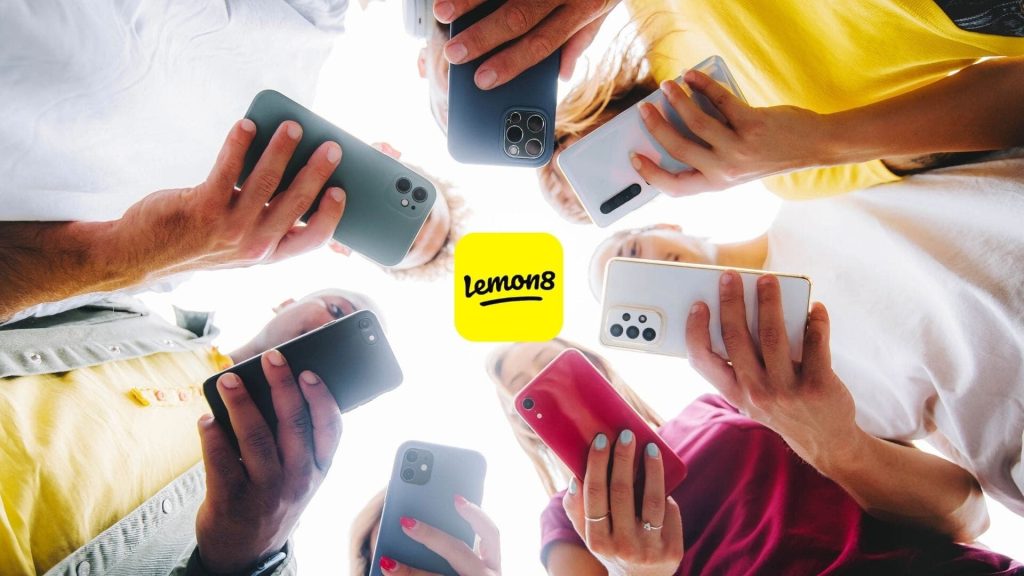 A group of people holding cell phones, exploring the Lemon8 App and discussing its features.